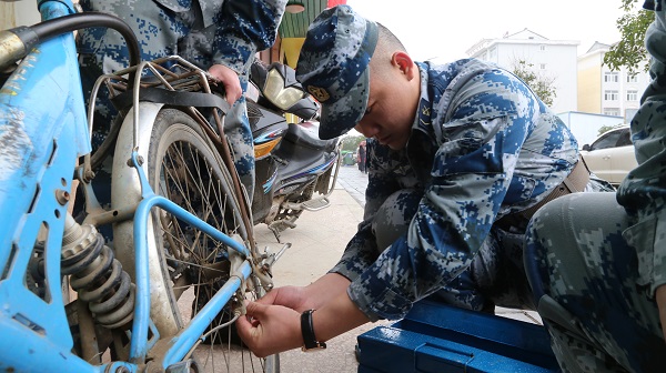 3官兵们为社区群众修理自行车.JPG