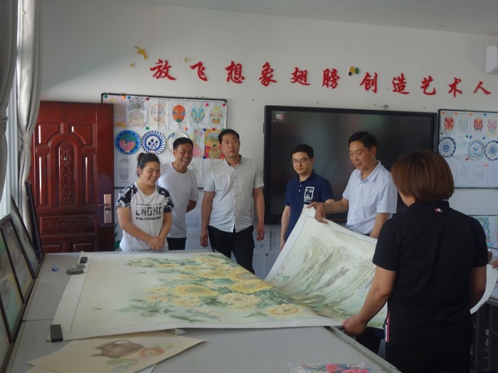 宋瑜副主任正在欣赏学校辅导教师的画作.jpg